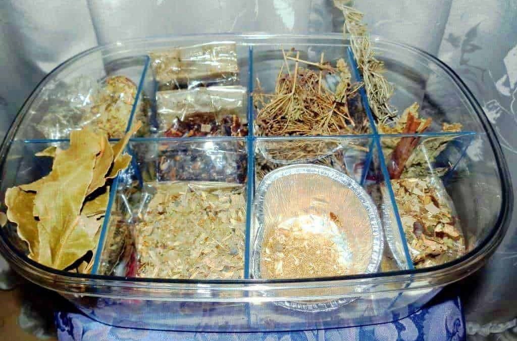 Scomparto di erbe medicinali e spezie essiccate in contenitore di vetro per rimedi naturali.