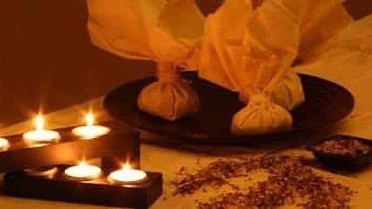 Ciotole di tessuto riempite di erbe aromatiche per aromaterapia e benessere, posizionate su una superficie con candele accese che creano un'atmosfera rilassante e intima.