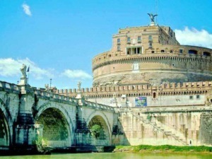 Castel Sant'Angelo a Roma, vista del pontificio e delle sue strutture storiche, simbolo di storia e cultura italiana, sotto un cielo azzurro e nuvole bianche.