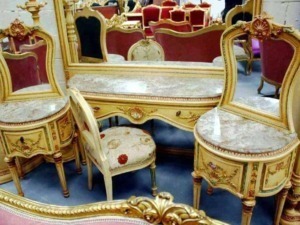 Lusso e eleganza arredamento antico in stile barocco con sedie e lavabo decorato in oro e velluto rosso. Perfetto per ambienti classici e raffinati.
