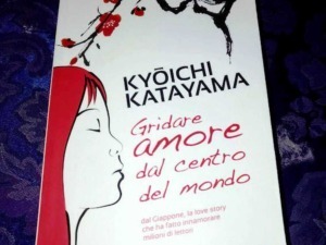 Libro "Gridare amore dal centro del mondo" di Kyōichi Katayama, cover con illustrazione di donna con capelli rossi e ramo di ciliegio in stile minimalista, su sfondo scuro.