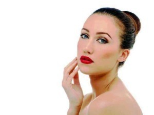 Luminosa donna con trucco elegante, occhi azzurri e labbra rosse, eleganza e stile in primo piano.