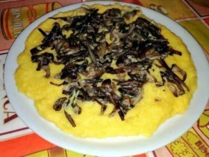 Frittata di uova con funghi trifolati, piatto tipico della cucina italiana, servito su piatto bianco in un ristorante rustico. Perfetto per una colazione o cenetta casalinga.