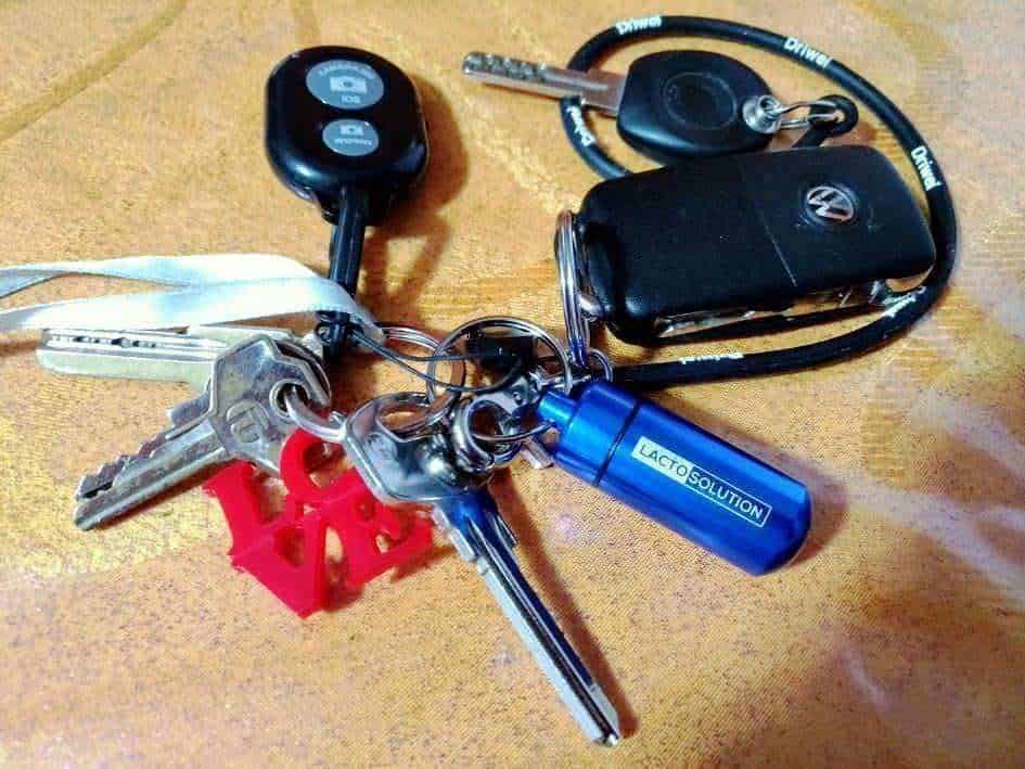 Chiavi, telecomando e chiavetta usb sul tavolo, accessori auto e strumenti tecnologici.