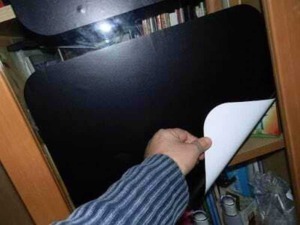 Fogli di carta bianca piegati e pronti per essere inseriti in una cartella o archivio, con uno sfondo di scaffali pieni di libri.