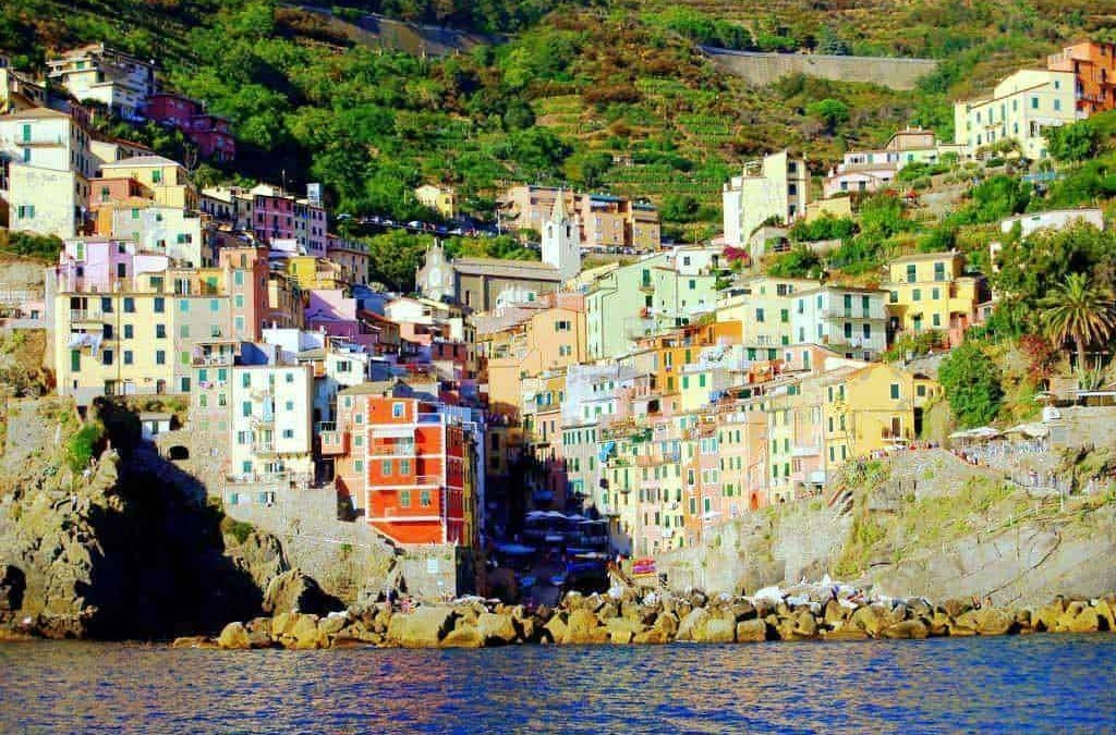 Colorato villaggio di case sulla scogliera, caratteristico della Costiera Amalfitana, con mare cristallino e paesaggi verdi, ideale per vacanze e turismo in Italia.