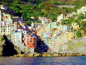 Colorato villaggio di case sulla scogliera, caratteristico della Costiera Amalfitana, con mare cristallino e paesaggi verdi, ideale per vacanze e turismo in Italia.