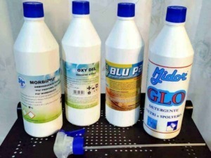 Prodotti per pulizia vetri e spolvero, detergenti e sbiancanti per superfici domestiche, bottiglie di detergente per sporco e polvere, strumenti per la pulizia domestica, prodotti chimici per la casa.