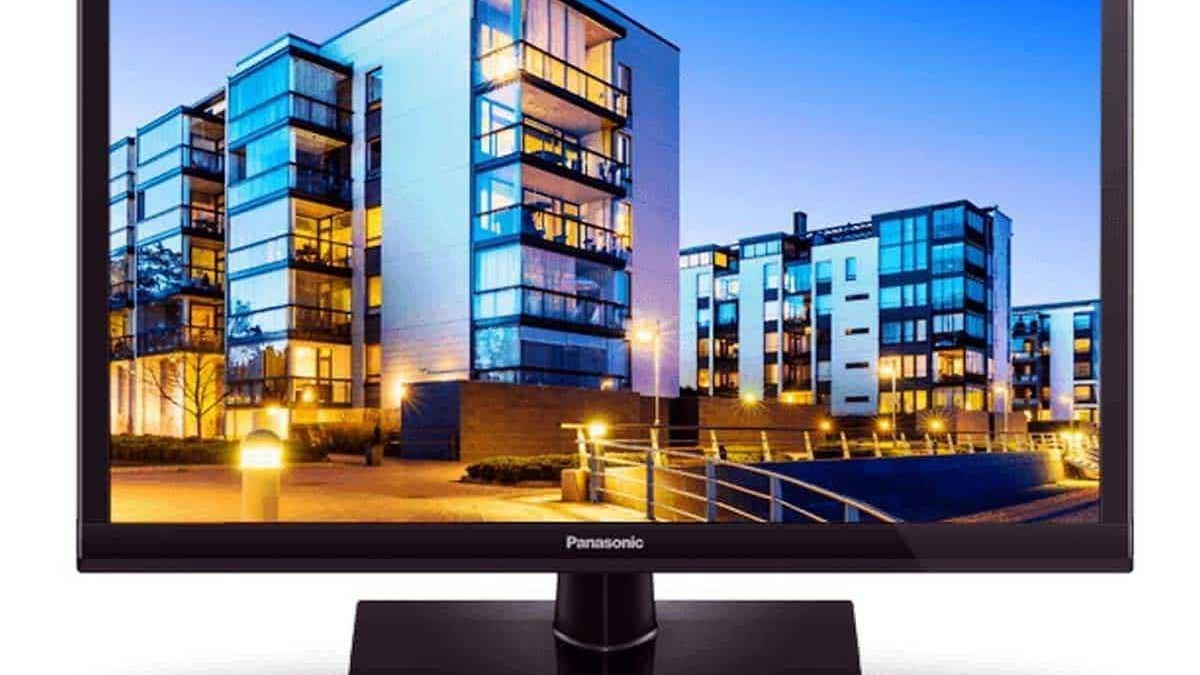 Moderno monitor Panasonic con schermo flatscreen che mostra un complesso residenziale urbano illuminato di sera, ideale per appassionati di tecnologia e design di interni.