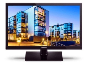 Moderno monitor Panasonic con schermo flatscreen che mostra un complesso residenziale urbano illuminato di sera, ideale per appassionati di tecnologia e design di interni.