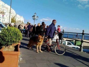 Passeggiata sul lungomare di Positano con turisti, biciclette, e vista sul mare, atmosfera vivace e panoramica.