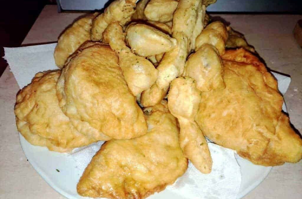 Pollo fritto croccante e dorato con pezzi di pollo fritti e patatine in una teglia, perfetta per una cena gustosa o un pranzo informale.