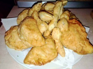 Pollo fritto croccante e dorato con pezzi di pollo fritti e patatine in una teglia, perfetta per una cena gustosa o un pranzo informale.