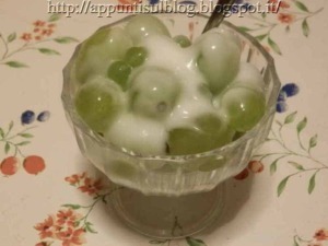 Uva bianca e verde in coppa di cristallo, dolce e fresca, ideale come dessert estivo o spuntino leggero.