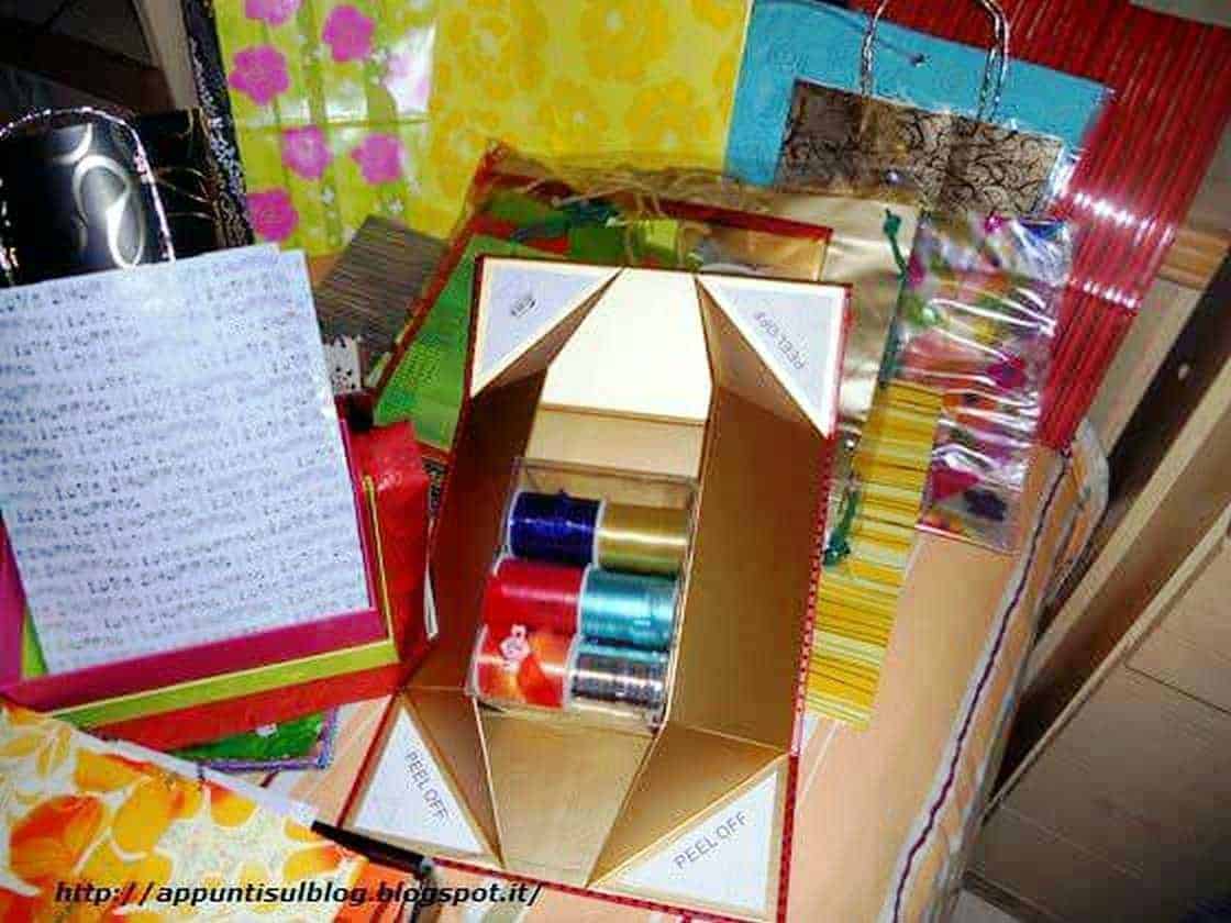 Cuori di carta rosa e decorazioni colorate in una scatola, ideali per regali o decorazioni romantiche, in stile festivo e creativo.