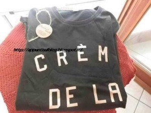 Crema di latte t-shirt nero casual, ideale per look estivi e alla moda, con grande stampa frontale, perfetta per appassionati di moda e lifestyle, immagini di abbigliamento trendy.
