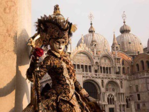 Venezia Carnevale Maschera storica donna in costume tradizionale andante su ponte in stile veneziano.