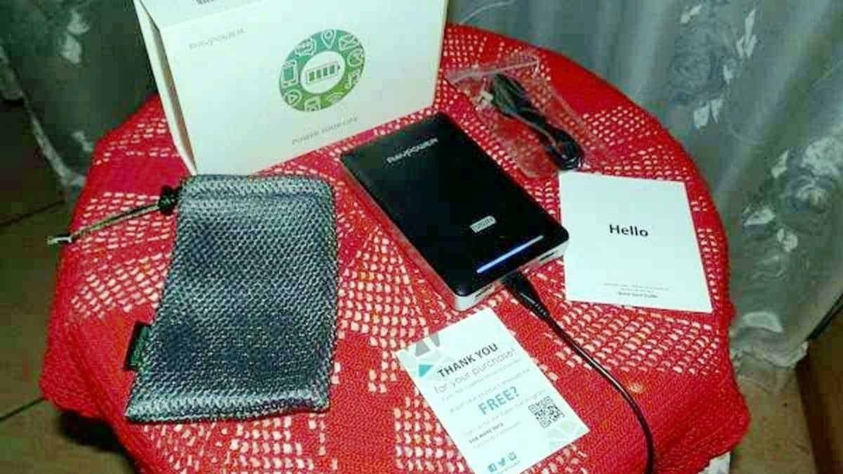 Caricabatterie portatile con cavo USB, confezione originale, e gialetta di ringraziamento; dispositivi tecnologici e accessori compresi in un pacchetto di gadget innovativi.
