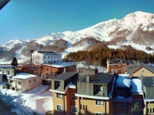 Valle innevato con case e montagna sullo sfondo, scena di montagna invernale con edifici e natura, foto di un paesaggio alpino innevato in Italia, perfetto per blog su viaggi e natura.