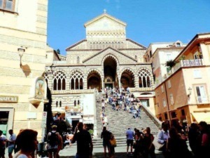 Immagine della chiesa di Santa Chiara e dei suoi iconici gradini a Napoli, con visitatori che salgono e scendono, catturando l’atmosfera vivace di un centro storico italiano.