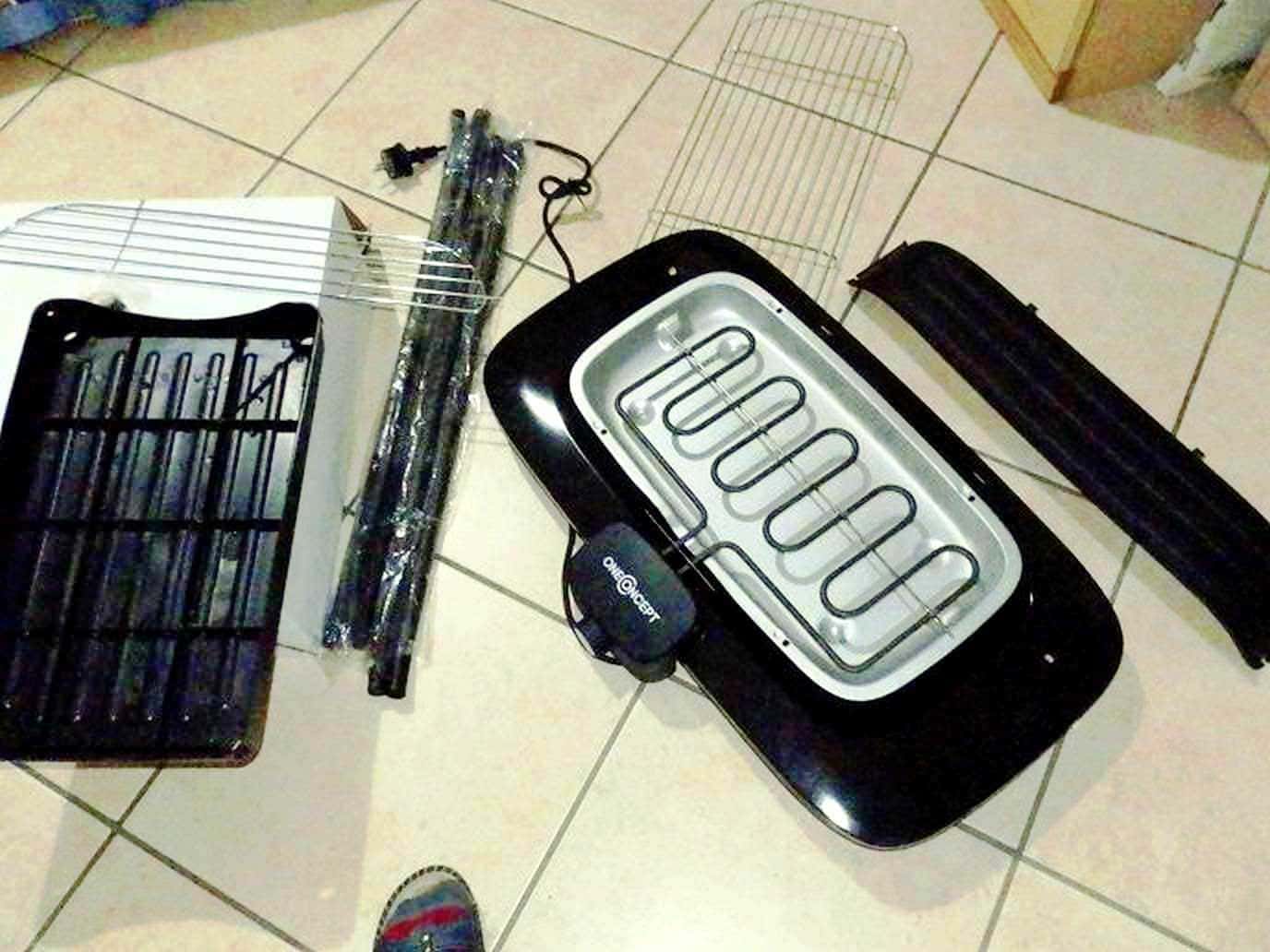 Pannelli radiatori e elementi di riscaldamento elettrico per la casa, smontati e disposti su piastrelle di ceramica, pronti per il montaggio o la sostituzione. Tecnologia e manutenzione degli impianti di riscaldamento.