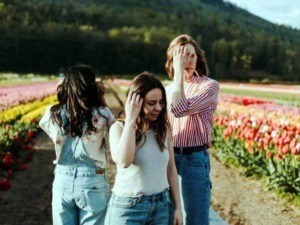 Fiori di tulipani in un campo primaverile con tre donne che si proteggono dal sole, atmosfera rilassante e scenografia naturale, perfetta per blog di lifestyle e viaggi.