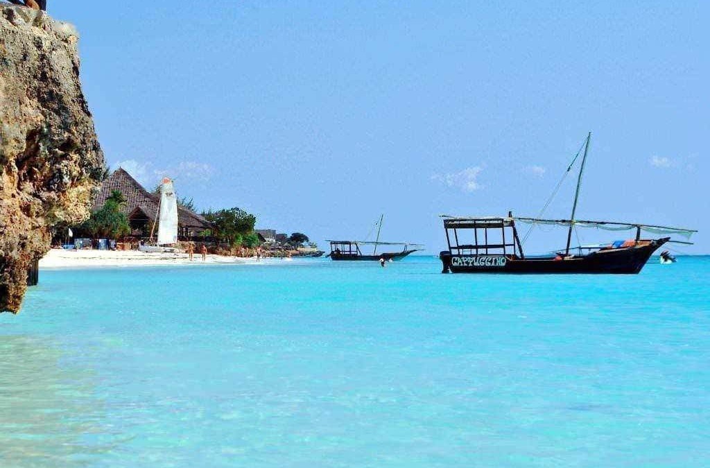 Spiaggia tropicale con barche a vela e acque cristalline in vacanza estiva, paesaggio marino rilassante, destinazione turistica di lusso, spiaggia bianca e acque turchesi, paradiso di mare.