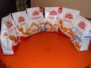 Dielé snack e biscotti assortiti su tavolo in casa, con vari gusti e texture, ideale per accompagnare momenti di relax o pausa merenda, ricchi di sapore e croccantezza.