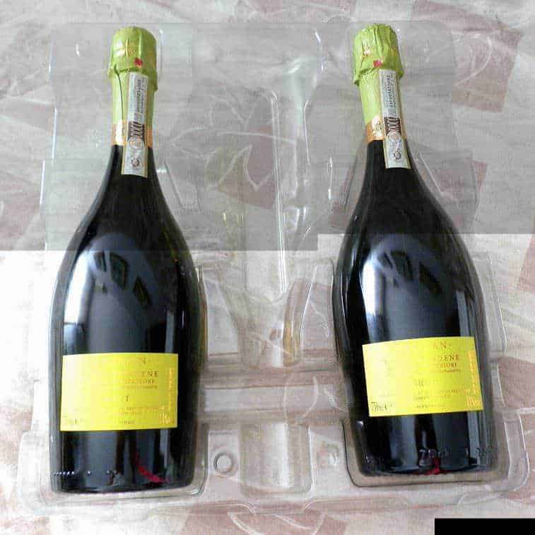 Bottiglie di Prosecco Drusian in vetro con etichette gialle, confezionate singolarmente in plastica protettiva, pronte per la vendita o la degustazione.