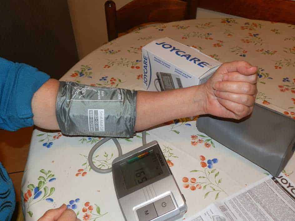Misuratore della pressione sanguigna attaccato al polso durante un controllo medico a casa. Immagine che mostra l'importanza del monitoraggio della salute e dell'autocura.