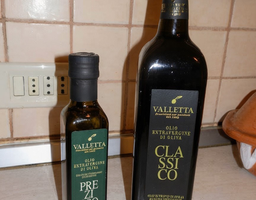 Olio extravergine di oliva VALLETTA predicato e Classico, bottiglie di diversa dimensione in cucina.