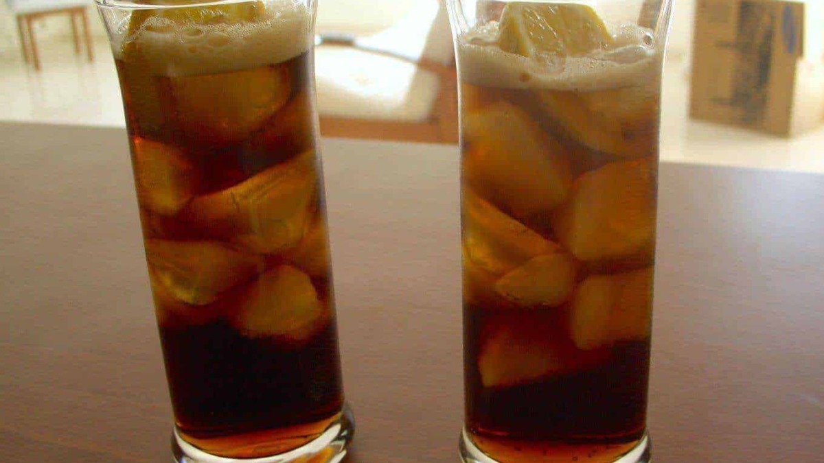 Fili di ghiaccio e limoni in due bicchieri di bevanda fredda con zucchero, su sfondo di una stanza luminosa. Perfetto per una bevanda estiva rinfrescante.