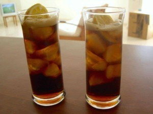 Fili di ghiaccio e limoni in due bicchieri di bevanda fredda con zucchero, su sfondo di una stanza luminosa. Perfetto per una bevanda estiva rinfrescante.