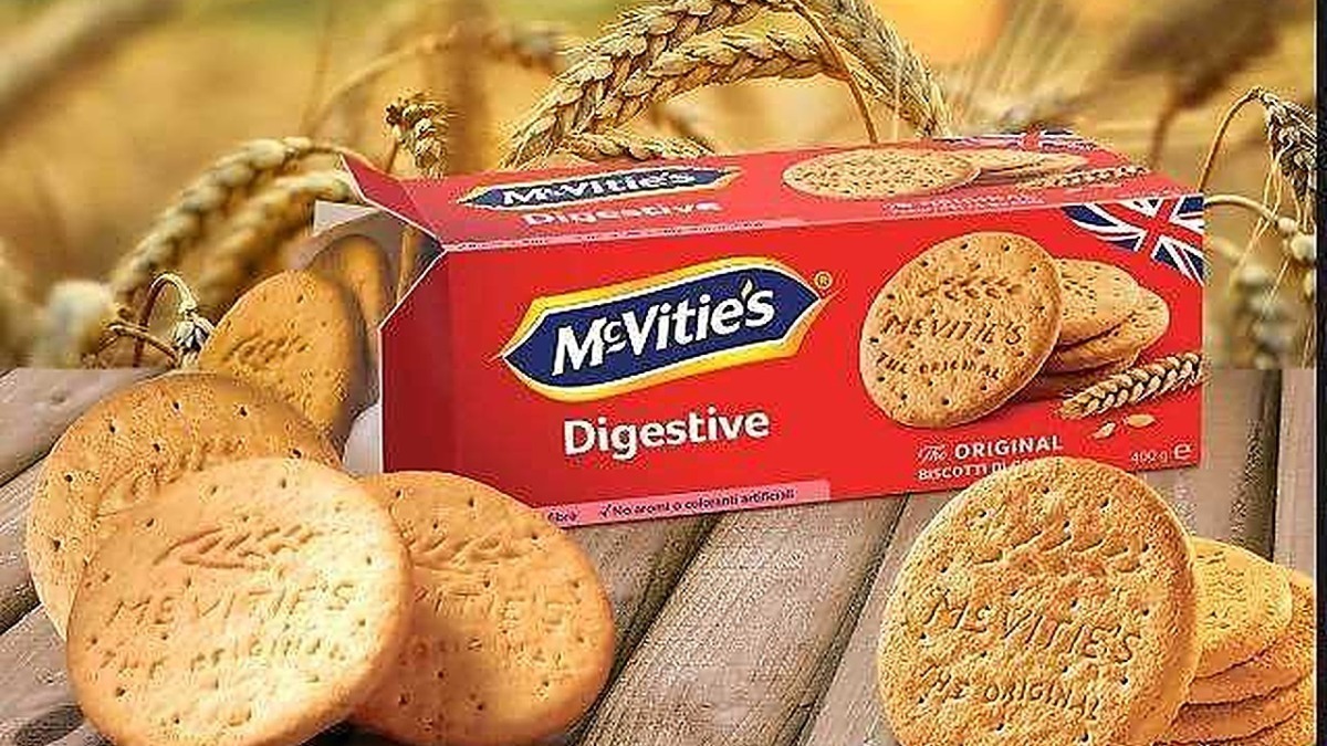 Deliziose biscotti McVitie's Digestive Original con confezione rossa e logo ben visibile su sfondo di spighe di grano. Ideali per una colazione o uno snack gustoso e genuino.