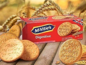 Deliziose biscotti McVitie's Digestive Original con confezione rossa e logo ben visibile su sfondo di spighe di grano. Ideali per una colazione o uno snack gustoso e genuino.