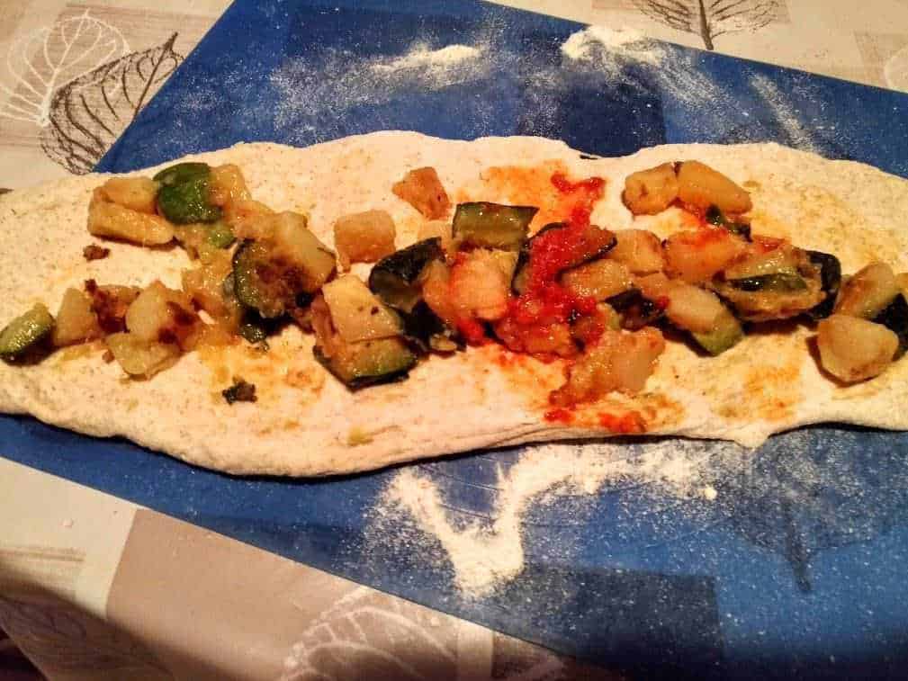 Pane fatta in casa con verdure grigliate e pomodoro, pronto per essere cotto in forno. Un piatto semplice e gustoso, perfetto per una cena leggera e salutare.