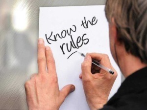 Immagine di una persona che scrive "Know the rules" su un foglio, simbolo di apprendimento e conoscenza delle regole.