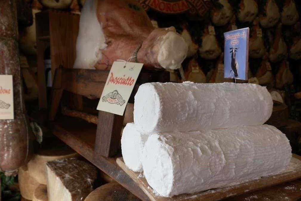 Formaggio fresco di mucca su scaffale in negozio di salumi e formaggi italiani, stagionature e prodotti tipici.