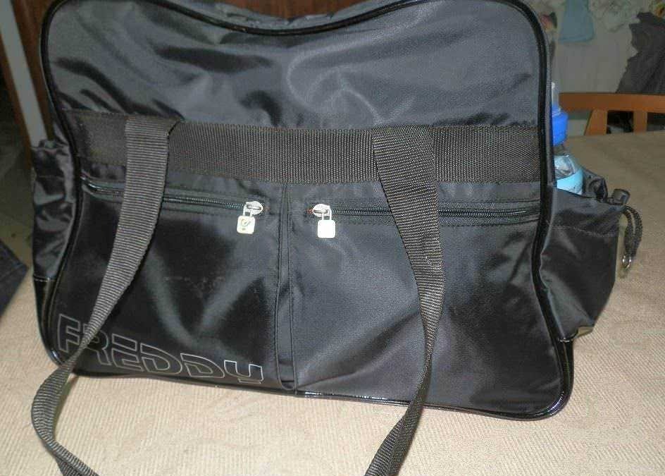 Borsa da viaggio nera con tasche e tracolla, ideale per sport e trasferte, in tessuto resistente e capiente, con scomparti organizzati e chiusure sicure per trasportare attrezzature e vestiti.