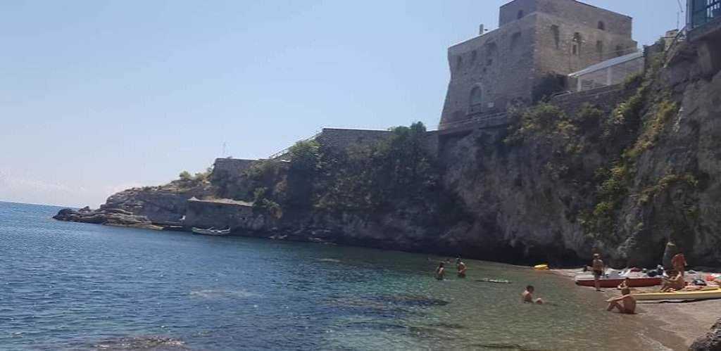 Erchie, vista mare con scogli e persone che fanno il bagno, atmosfera estiva e panorami, luogo di relax e natura, ideale per fotografie turistiche e paesaggistiche