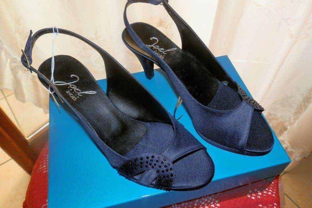 Sandali neri con tacco alto e cinturino alla caviglia su scatola blu, perfetti per occasioni eleganti e look glamour, ideali per donna moderna e fashion.