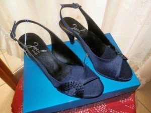 Sandali neri con tacco alto e cinturino alla caviglia su scatola blu, perfetti per occasioni eleganti e look glamour, ideali per donna moderna e fashion.