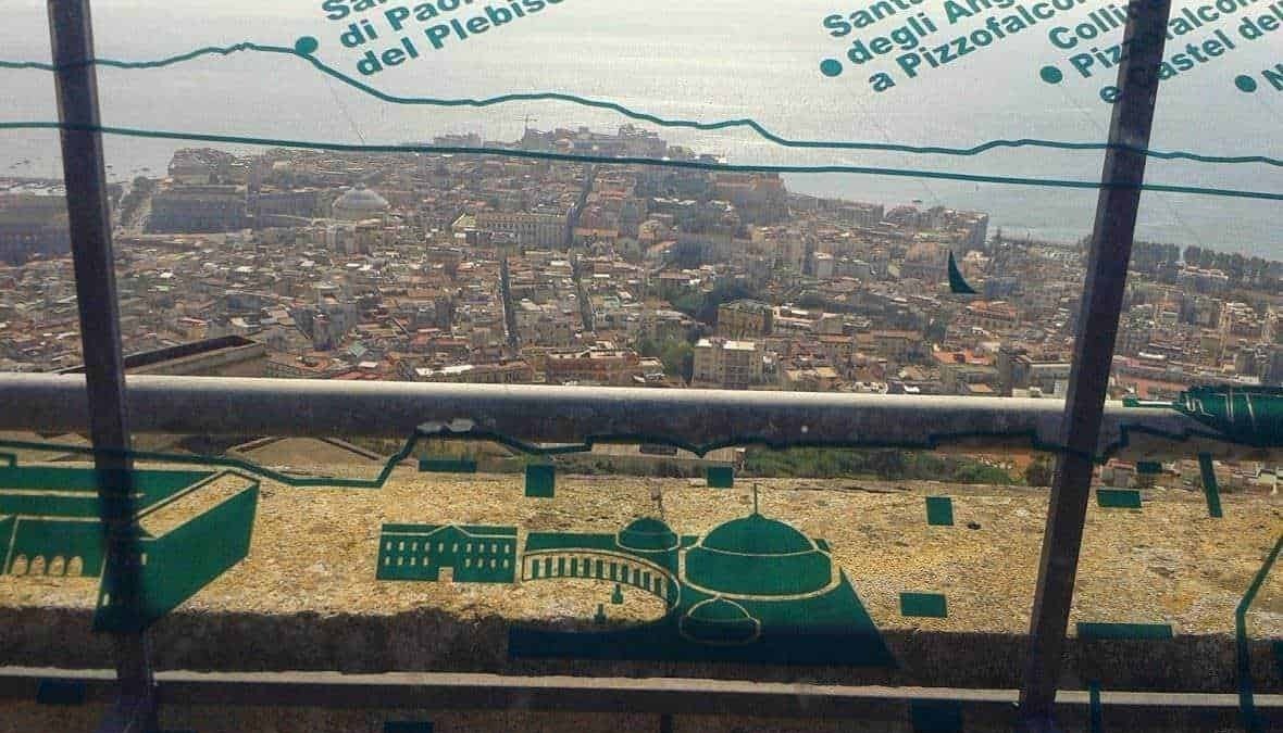 Panorama di Palermo dal Tempio di Segesta con vista sulla città e il mare, visibile attraverso una protezione in vetro con scritte informative, in una giornata soleggiata.