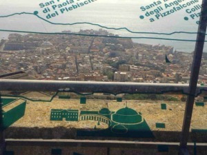 Panorama di Palermo dal Tempio di Segesta con vista sulla città e il mare, visibile attraverso una protezione in vetro con scritte informative, in una giornata soleggiata.