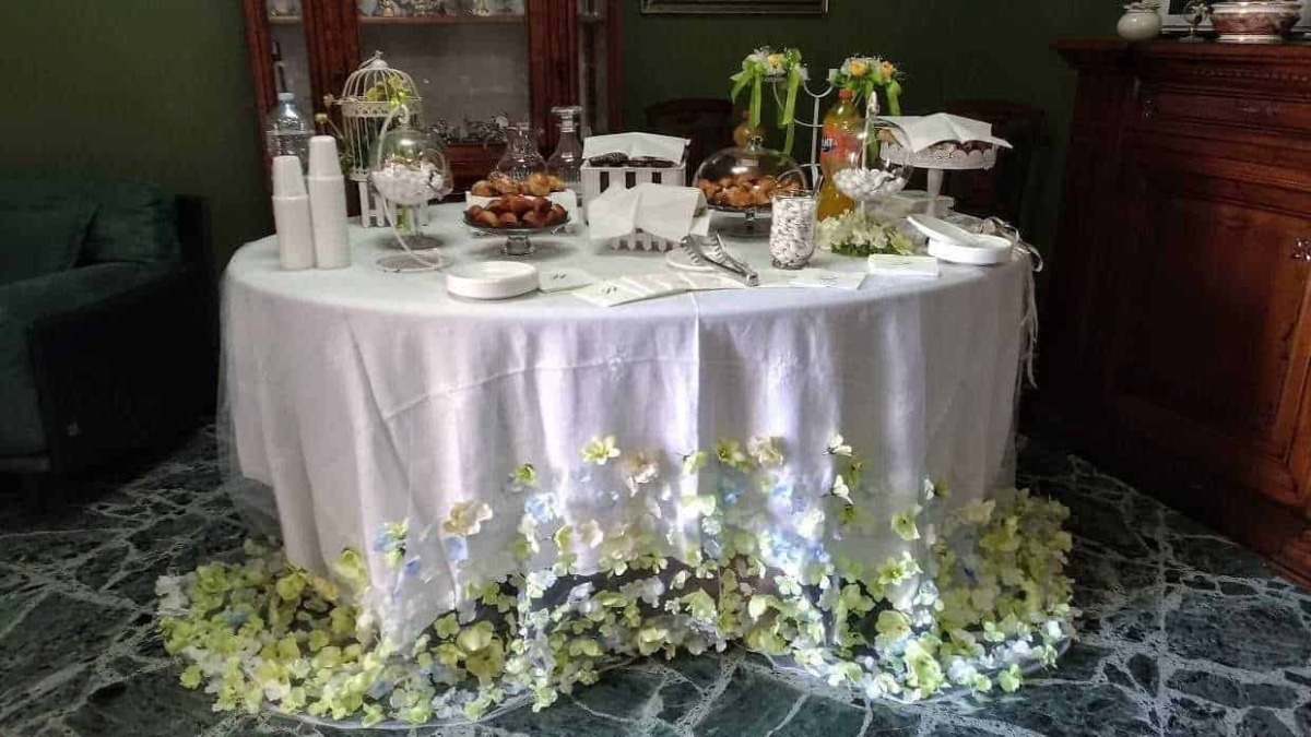 Piatti decorativi su tavola imbandita per evento speciale, con fiori e oggetti eleganti, atmosfera raffinata e accogliente.