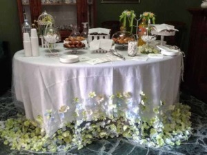 Piatti decorativi su tavola imbandita per evento speciale, con fiori e oggetti eleganti, atmosfera raffinata e accogliente.