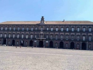 Palazzo storico in piazza con architettura classica, situato nel cuore di Napoli, Italia, esempio di edifici storici e monumenti italiani.