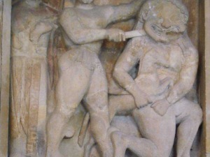 Uomo che sorregge un mostro mitologico in scultura in pietra, stile antico, rappresentando mitologie e leggende dell'antichità.