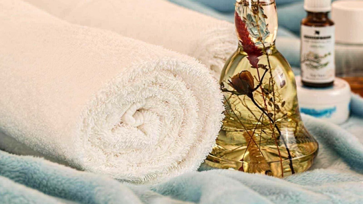 Profumo rilassante di oli essenziali con tovagliolo di spugna e flacone di olio aromatico per massaggi e aromaterapia.