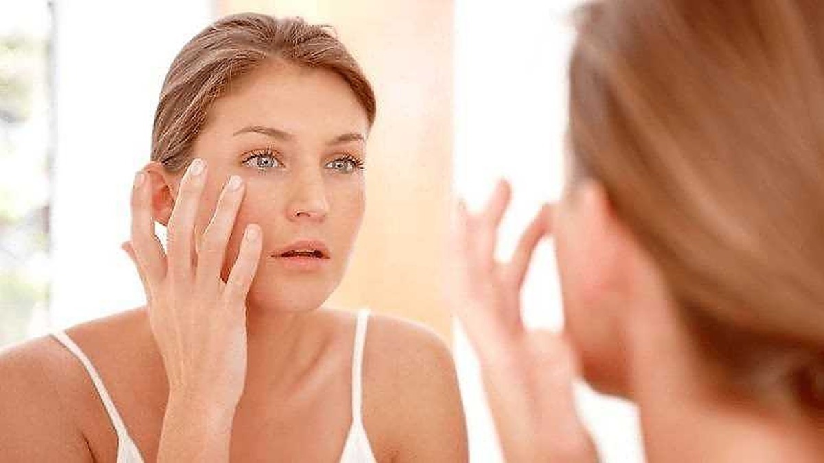 Pelle fresca e cura della routine di bellezza, giovane donna che si guarda allo specchio, cura del viso dermatologia e skincare.